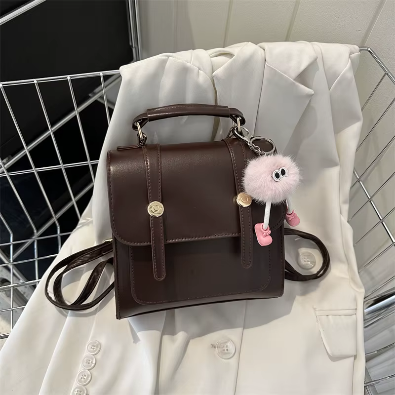 Sac à dos décontracté vintage en similicuir avec breloque en peluche mignonne, sac à bandoulière rétro à rabat avec poignée supérieure pour femme, idéal pour les trajets quotidiens